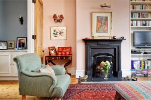 a living room with a chair and a fireplace at Veeve - Vividly Vintage in London