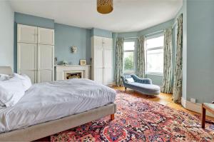 - une chambre avec un lit, une chaise et une cheminée dans l'établissement Veeve - Vividly Vintage, à Londres