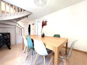 - une salle à manger avec une table et des chaises en bois dans l'établissement Belle Demeure en bord de Seine, à Villeneuve-la-Garenne