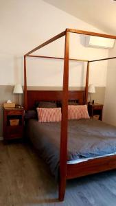 1 cama en una habitación con 2 mesitas de noche y 2 lámparas en Charmante maison de village, en Mondragon