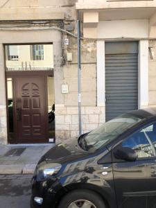 un'auto parcheggiata di fronte a un edificio con porta di Casa Anita a Bari