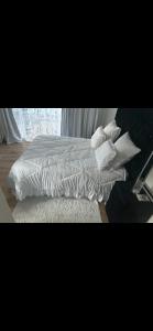 - un lit avec des draps et des oreillers blancs dans l'établissement Urban Fourways Haven, à Sandton