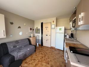 a small living room with a couch and a kitchen at Studio cabine avec piscine, parking sécurisé et accès direct plage à Saint-Cyprien - FR-1-753-15 in Saint-Cyprien