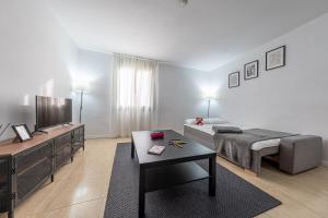 Una sala de estar con una cama y un televisor. en URBAN Center Apartments, en Tarragona 146 fotos más