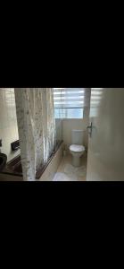 a bathroom with a white toilet and a sink at Urban Fourways Haven in Sandton