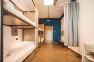 Lecco Hostel & Rooms في ليكو: غرفة بسريرين بطابقين وممر