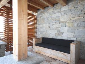 a wooden bench sitting in front of a stone wall at Appartement Les Arcs 1800, 3 pièces, 4 personnes - FR-1-346-569 in Bourg-Saint-Maurice
