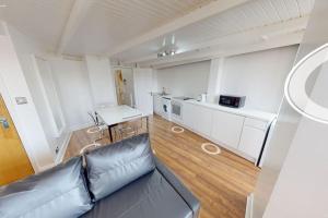 a living room with a couch and a kitchen at Sleeps up to 4 - City Centre in Nottingham