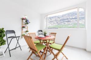 jadalnia ze stołem i krzesłami oraz oknem w obiekcie Apartamento Fabi w mieście Puerto Naos