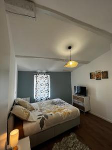 um quarto com uma cama grande e uma janela em La maison castelpontine T4 em Pont-du-Château