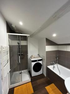 uma casa de banho com um chuveiro, uma banheira e um lavatório. em La maison castelpontine T4 em Pont-du-Château