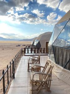 une terrasse avec des chaises et une vue sur le désert dans l'établissement Hilton Wadi rum, à Disah