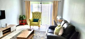 sala de estar con sofá negro y silla amarilla en Comfort in Glen Austin, Midrand, en Midrand