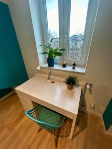 a desk in front of a window with plants on it at Apartment Targowa L15 in Lublin