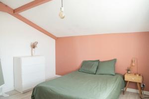 1 dormitorio con cama verde y paredes rosas en Maison au cœur du Pays Basque, en Cambo-les-Bains