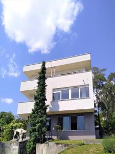 un edificio blanco con un árbol delante en WOLKENHAWK en Zagreb