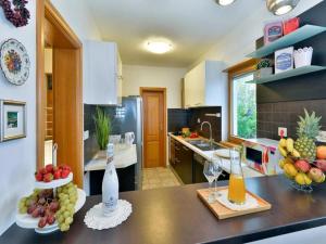 札格雷布的住宿－WOLKENHAWK，厨房配有带水果和酒杯的吧台
