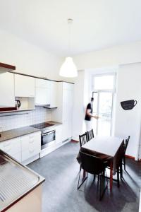 a man standing in a kitchen with a table and chairs at Großes, Helles Vintage Apartment mit Parkplatz in Innsbruck