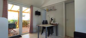 a room with a table and a balcony with a sliding glass door at Franck's tiny house in Lège-Cap-Ferret