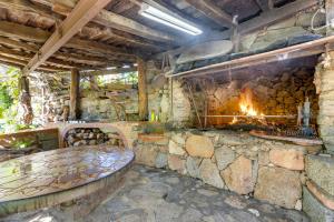a stone fireplace in a room with a bench and a fire place at Villa Orgoai in Orgosolo