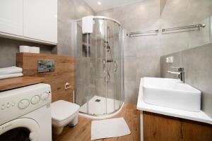 uma casa de banho com um chuveiro, um WC e um lavatório. em Rudzka Góra Comfy Apartment em Lódź