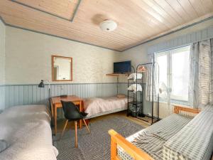 a bedroom with two beds and a desk and a window at Sova Guesthouse in Sodankylä