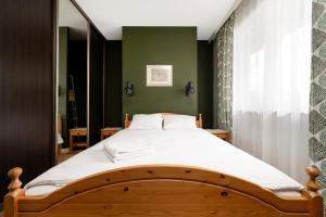 łóżko w sypialni z zieloną ścianą w obiekcie Rudzka Góra Comfy Apartment w Łodzi