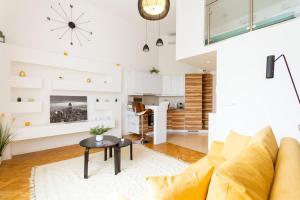 - un salon avec un canapé jaune et une table dans l'établissement Bright Design Riverside Studio by NW, à Budapest