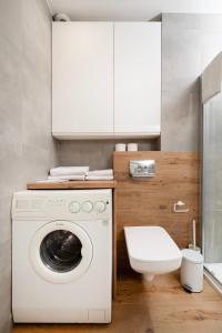 a white washing machine in a bathroom with a toilet at Rudzka Góra Comfy Apartment in Łódź