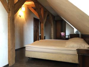 a bedroom with a large bed in an attic at Folwark Polski in Ostrów Wielkopolski