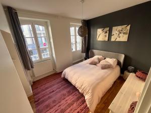een kleine slaapkamer met een bed met witte lakens bij Cosy Center Av Des États-Unis in Clermont-Ferrand