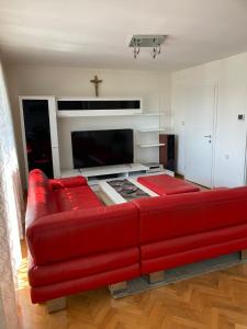 a red couch in a living room with a fireplace at Astralis Factory Apartments- FLY in Zagreb
