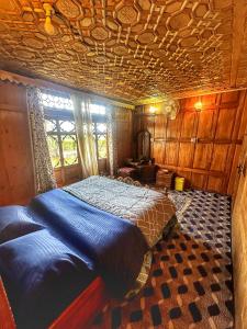 a bedroom with a blue bed in a room at Pasadona Floating Houseboat in Srinagar