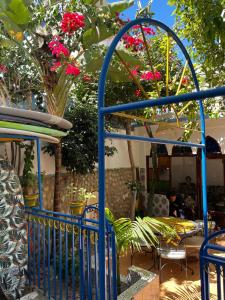 una puerta de metal azul con flores en un patio en CampSurf Morocco, en Tamraght Ouzdar