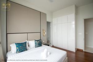 a bedroom with a large white bed with blue pillows at PAVILION EMBASSY KLCC By ELITE HOST in Kuala Lumpur