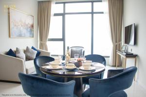 a living room with a table and blue chairs at PAVILION EMBASSY KLCC By ELITE HOST in Kuala Lumpur