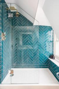 a bathroom with a shower with blue tiles at Beautiful Central 2 Bed Flat in Bath
