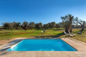 una piscina en medio de un campo en Trullo Mandorlo by BarbarHouse, en Carovigno