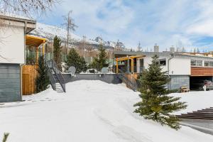 Una casa en la nieve con un árbol de Navidad en Mountain Villas Polana, en Nový Smokovec