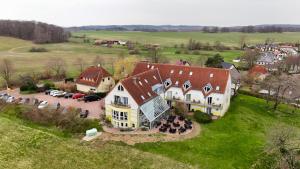 an aerial view of a large house in a field at Inselhotel kleiner Bodden in Buschvitz