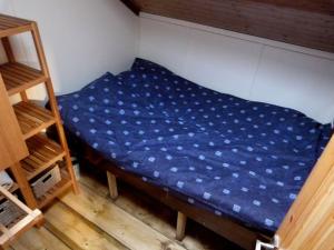a bed in a room with a blue sheet on it at Sailing Barge Reminder in Maldon