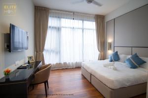 a hotel room with a bed and a desk and a television at PAVILION EMBASSY KLCC By ELITE HOST in Kuala Lumpur