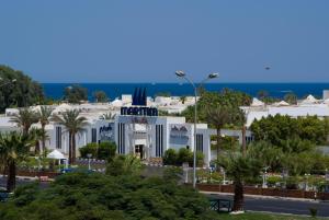 biały budynek z palmami nad oceanem w obiekcie Maritim Jolie Ville Resort & Casino w Szarm el-Szejk