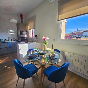 a dining room with a glass table and blue chairs at Authentic Madrid Experience -Plaza Mayor 7min walk - Spectacular view - Champagne in Madrid