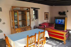 sala de estar con TV, mesa y sillas en Casa Rural El Cura, en Agüimes