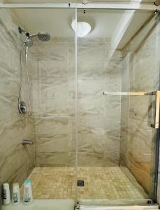 y baño con ducha y puerta de cristal. en Cozy Haven: Modern 2-Bedroom Retreat en Brampton