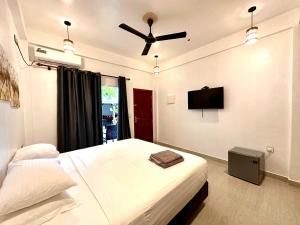 1 dormitorio con 1 cama y ventilador de techo en Thoddoo Island Life, en Thoddoo