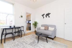 a living room with a table and a couch at Spacious 4 bed in Coventry City Centre, Sleeps up to 7. in Parkside