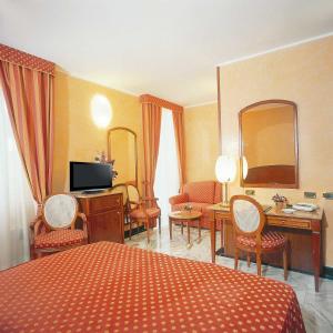 a hotel room with a bed and a desk with a television at Hotel Ulivi in Arenzano