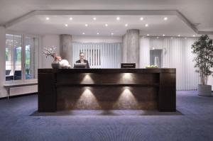 a woman sitting at a desk in a lobby at nordica Hotel Berlin in Heide